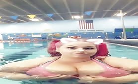 Teasing with her big tits in a public pool